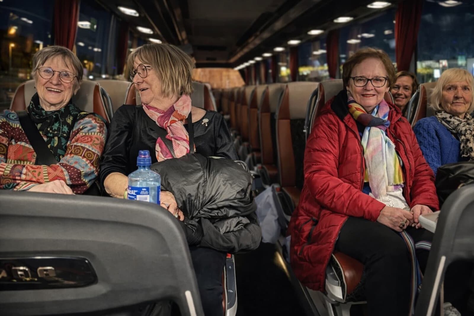 Smilende deltakere i bussen på kveldstur